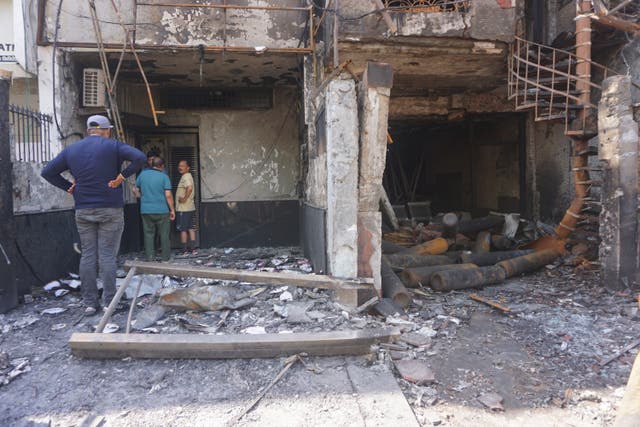 <p>People look at the burnt building of a baby hospital in Delhi on Sunday</p>