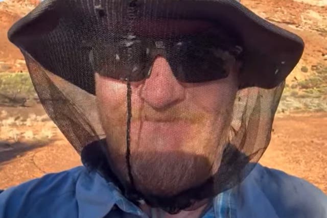 <p>A man wears a net hat for protection from bush flies</p>